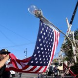 Firefighters get ready to raise tree and the flag.